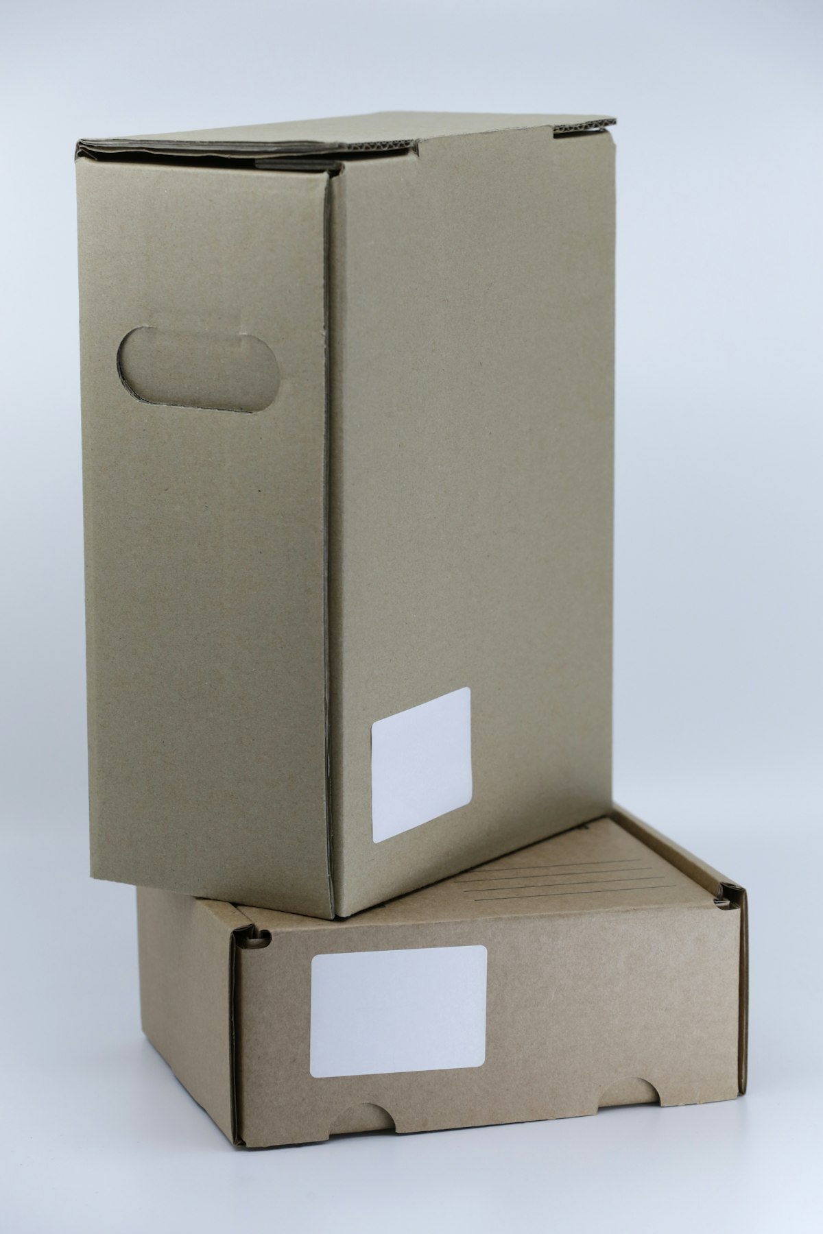 Simple cardboard shipping boxes stacked on a white table